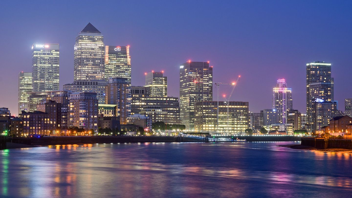 Les tours de bureaux illuminées de Canary Wharf, la nuit, vues de l'autre rive de la Tamise.