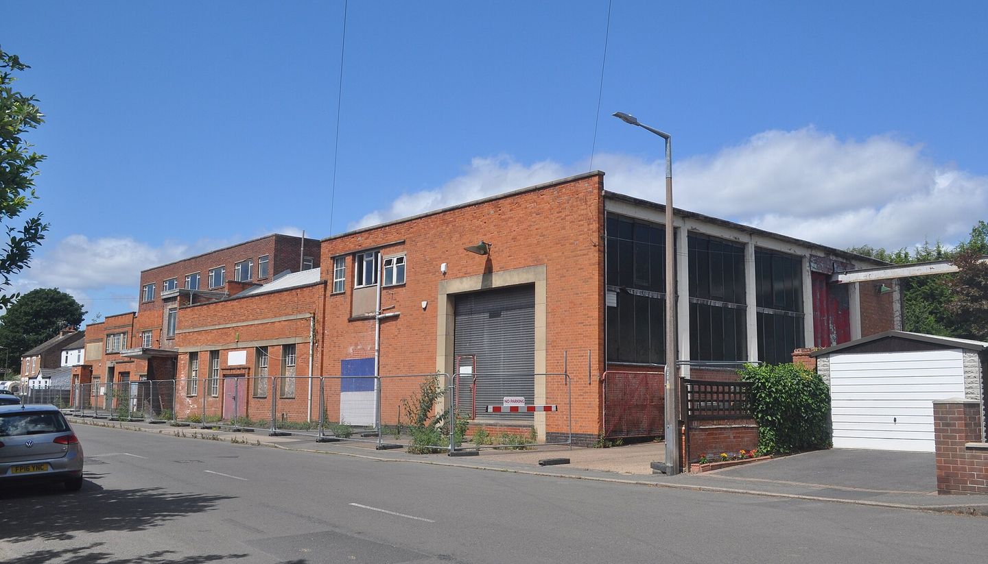 A vacant brick factory building on an empty street.