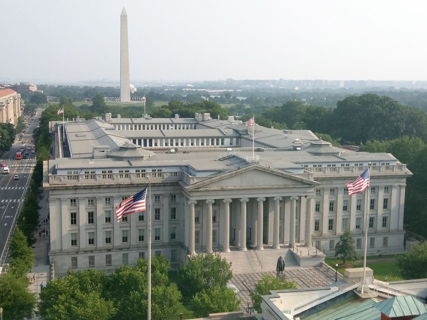 Le bâtiment du Trésor américain vu du ciel, l'obélisque du Washington Monument se dressant en arrière-plan.